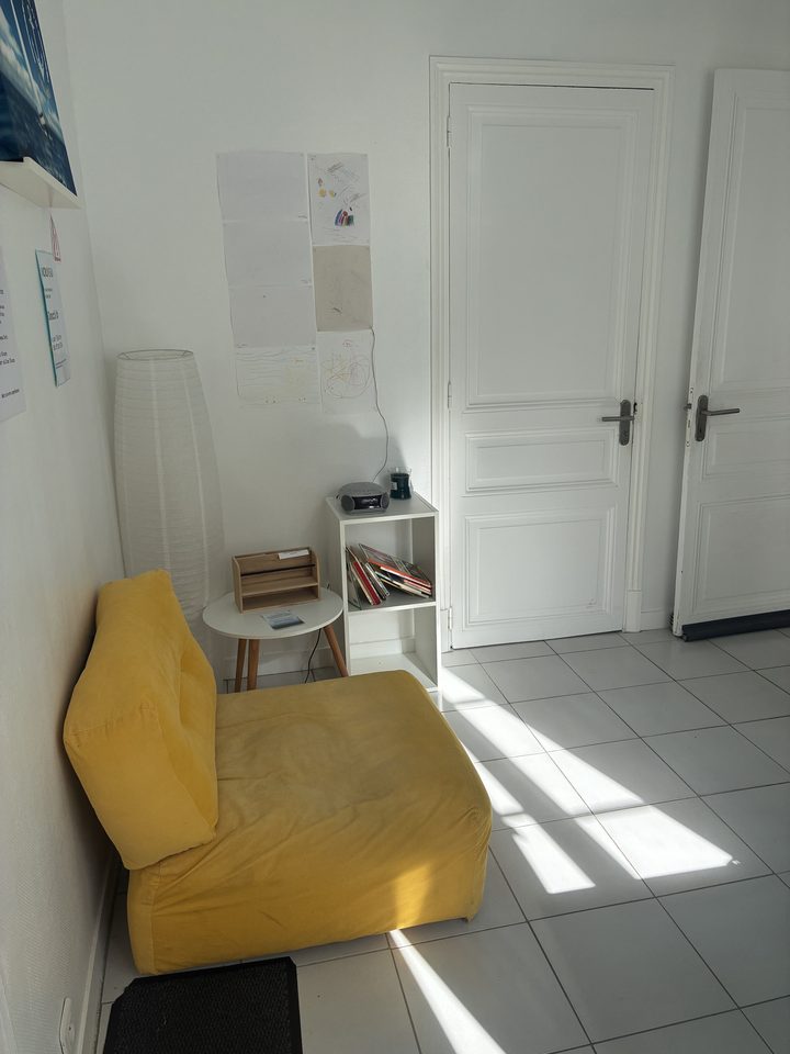 Salle d'attente lumineuse et accueillante du cabinet, avec un coin lecture pour les enfants